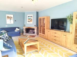 a living room with a couch and a flat screen tv at Villa San Lure Jaca in Jaca