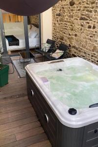 a jacuzzi tub in a room with a bedroom at Charmant logement avec jacuzzi in Fougères