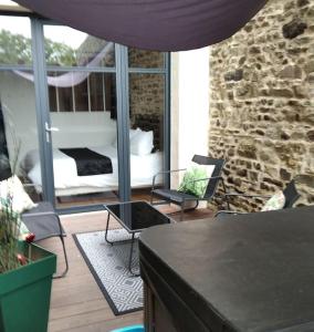 sala de estar con cama y pared de piedra en Charmant logement avec jacuzzi, en Fougères