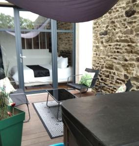 a living room with a bed and a stone wall at Charmant logement avec jacuzzi in Fougères