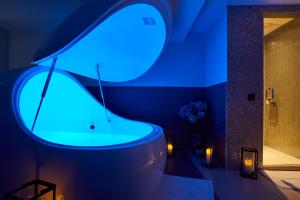 a bathroom with a tub with a blue light at Dormy House Hotel in Broadway