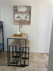 a table with a vase on it next to a wall at Bienvenue en Beaujolais in Saint-Jean-dʼArdières