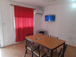 a room with a table with chairs and a red curtain at Mercedario Aparts in Barreal