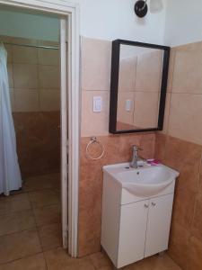 un bagno con lavandino, specchio e doccia di Mercedario Aparts a Barreal Altre 13 foto