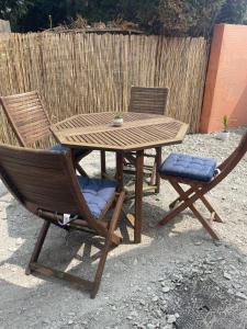 a wooden table and two chairs and a wooden table and chairs at Bienvenue en Beaujolais in Saint-Jean-dʼArdières