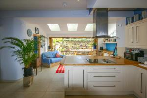 uma cozinha com um lavatório e uma sala de estar em Overdene - Luxury House With Magnificent Sea Views em Tintagel