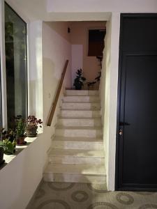 una escalera en una casa con una puerta negra en Apartaments Queen, en Ulcinj