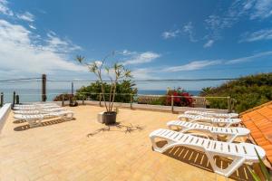 a row of white lounge chairs on a patio at Calas De Meca in Los Caños de Meca