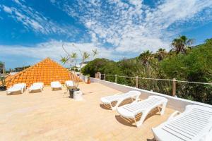a group of white chairs sitting on a patio at Calas De Meca in Los Caños de Meca