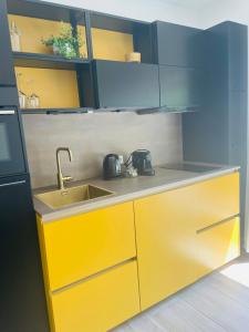 a kitchen with yellow cabinets and a sink at Zomeren Domburg in Domburg