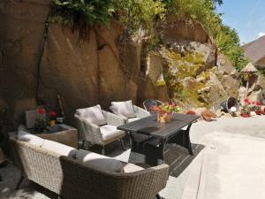 a patio with a table and wicker chairs at Apartments Haus Erna in Weitra