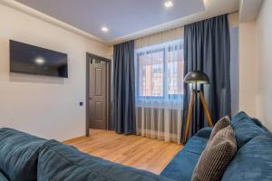 un soggiorno con divano blu e finestra di Spacious 2-bed. Perfect for family & friends a Gudauri