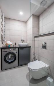 bagno con servizi igienici, lavandino e lavatrice di Spacious 2-bed. Perfect for family & friends a Gudauri