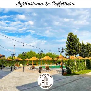 a resort with a pool with umbrellas and a sign at Agriturismo La Caffettiera in Sparanise