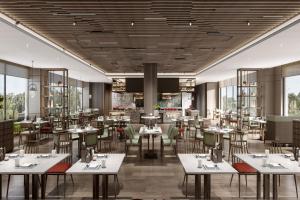 a rendering of a restaurant with tables and chairs at Delta Hotels by Marriott Jiuzhaigou in Jiuzhaigou