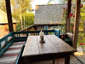 drewniany stół na ganku domu w obiekcie The Village Pension w mieście Breb