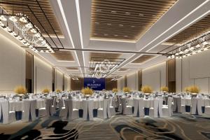 duża sala bankietowa z białymi stołami i krzesłami w obiekcie Delta Hotels by Marriott Jiuzhaigou w mieście Jiuzhaigou