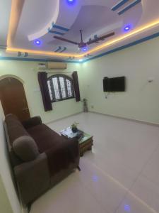a living room with a couch and a tv at Serene Homestay in Panaji
