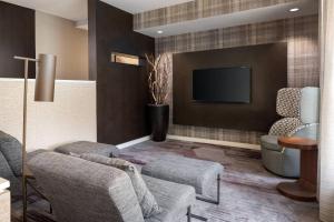 sala de estar con 2 sillas y TV en Courtyard Fremont Silicon Valley, en Fremont