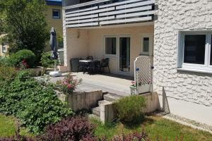 a house with a patio with a table and a chair at Schöne Ferienwohnung direkt am Neckar in Deißlingen