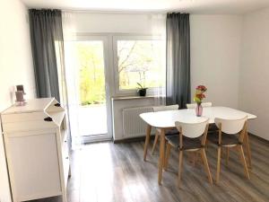 a white dining room with a white table and chairs at Schöne Ferienwohnung direkt am Neckar in Deißlingen