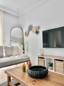a living room with a tv and a tire on a coffee table at Capucines La Marsa plage in La Marsa