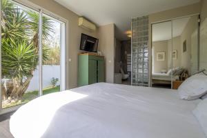 a bedroom with a white bed and a large window at Envie de Vivre in Agde +24 photos