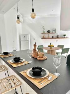 a kitchen with a table with plates and wine glasses at Capucines La Marsa plage in La Marsa
