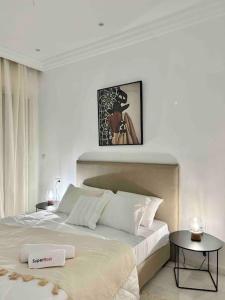 una camera da letto bianca con un letto grande e un tavolo di Capucines La Marsa plage a La Marsa