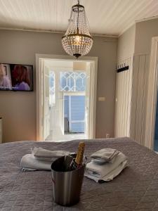 a bedroom with a bed with a bottle of wine in a bucket at Kapteeninmökki in Naantali