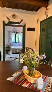 a table with a basket of fruit and flowers on it at The Village Pension in Breb