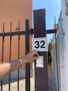 Un hombre sosteniendo un cartel con el número. en B&B Licia Home, en Voghera