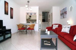 a living room with a red couch and a table at 2 bedroom apartment in Vale do Lobo in Vale do Lobo