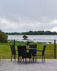 a table and chairs with a view of a river at Lough Beg Glamping in New Ferry