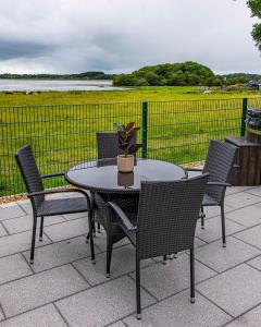 a table and chairs with a potted plant on a patio at Lough Beg Glamping in New Ferry