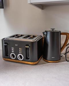 a black toaster and a tea pot on a counter at Lough Beg Glamping in New Ferry