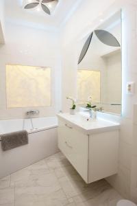 a white bathroom with a sink and a bath tub at Luxurious Central Apartment next to the Danube River in Budapest