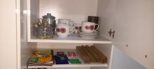 un armario blanco con tazas y platos en un estante en Espíritu Joven en Formosa