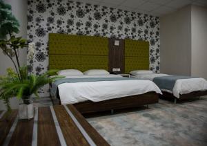 a room with two beds in a room at Rawaz Hotel & Motel in As Sulaymānīyah