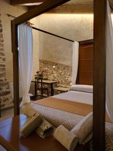 a bedroom with two beds and a table with a table sidx sidx at Casa rural El Forn d'Alcudia de Veo in Alcudia de Veo