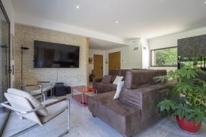 Una sala de estar con un sofá y un televisor. en Villa Orsan, en Orsan