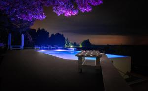 a swimming pool at night with a table and chairs at SEA VIEW Ranch By the Sea in Vatopedi