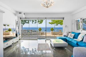 a living room with a blue couch and a view of the ocean at SEA VIEW Ranch By the Sea in Vatopedi