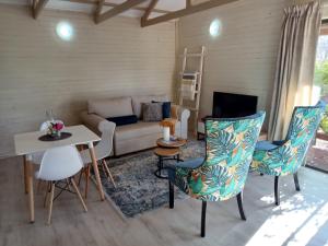 een woonkamer met een bank en een tafel en stoelen bij Cinnamon & Sage Country Cabins in Dullstroom