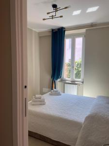 1 dormitorio con 1 cama con cortinas azules y ventana en B&B Licia Home, en Voghera