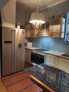 eine Küche mit einem Kühlschrank und Schränken aus Edelstahl in der Unterkunft Seaside Artistic Apartment in Glyfada in Athen