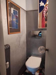 ein kleines Bad mit WC und Bildern an der Wand in der Unterkunft Seaside Artistic Apartment in Glyfada in Athen
