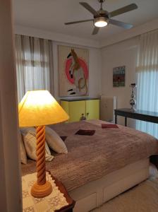 Schlafzimmer mit einem Bett und einer Lampe auf einem Tisch in der Unterkunft Seaside Artistic Apartment in Glyfada in Athen