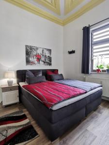 - une chambre avec un grand lit et une couverture rouge dans l'établissement Ferienwohnung La Finesse, à Bad Salzungen
