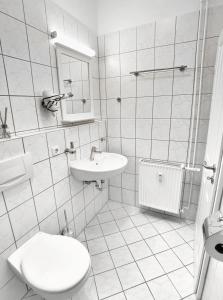 a white bathroom with a toilet and a sink at Ferienwohnung La Finesse in Bad Salzungen +23 photos